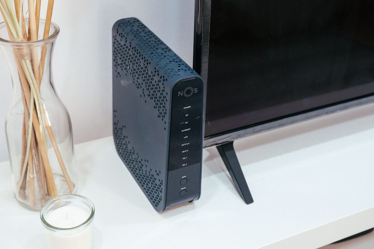 Router bezprzewodowy ustawiony w salonie obok telewizora