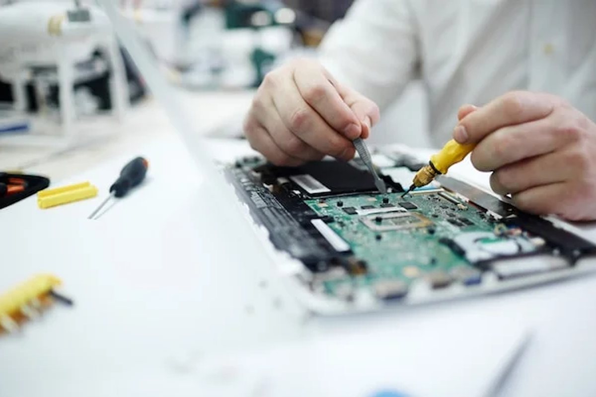 Dłonie naprawiające płytę główną laptopa — naprawa laptopów Sony VAIO