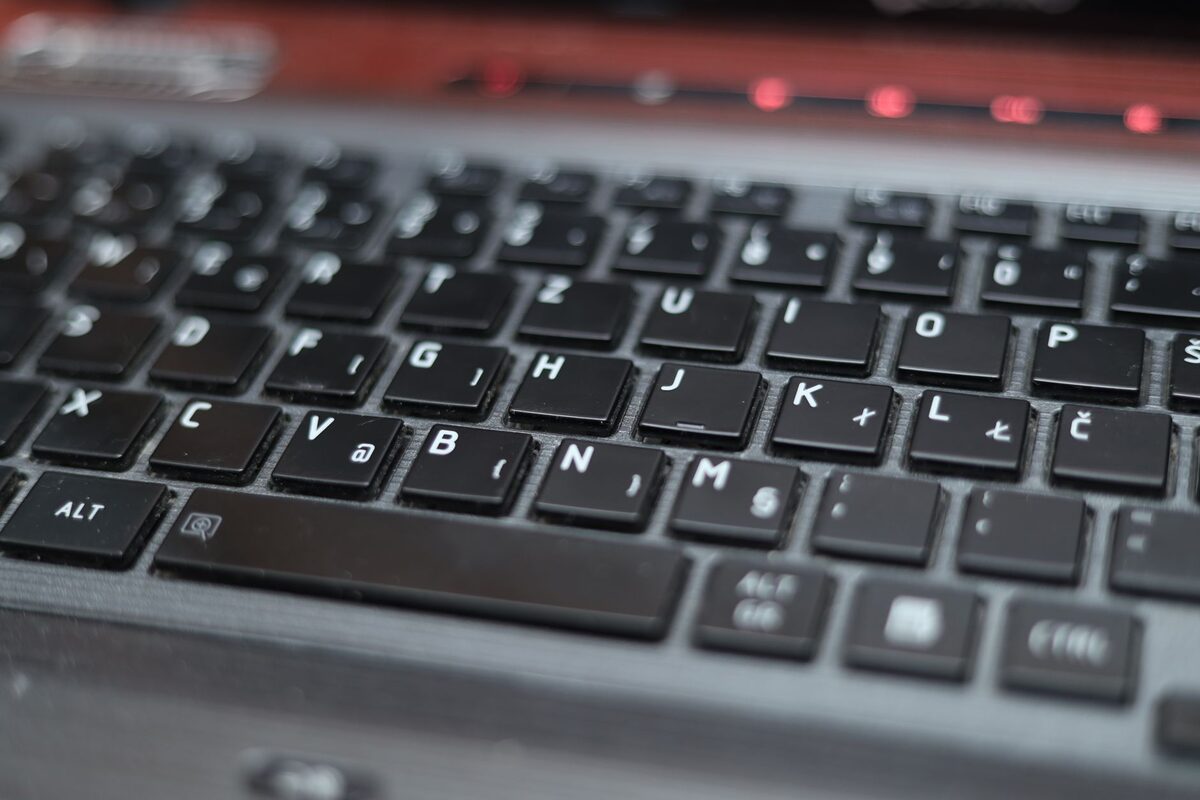 Klawiatura i obudowa laptopa w ciemnej kolorystyce, zbliżenie